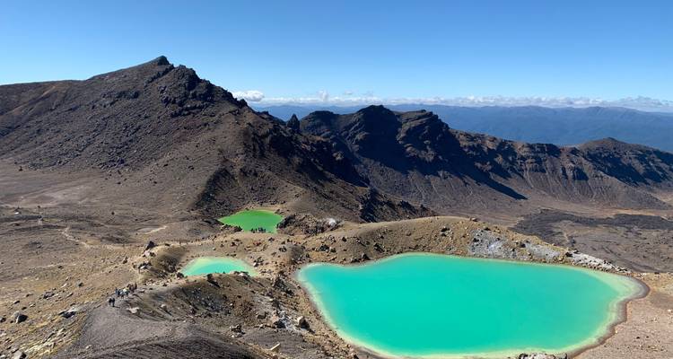 Bunte Vulkanseen mit Bergen im Hintergrund.
