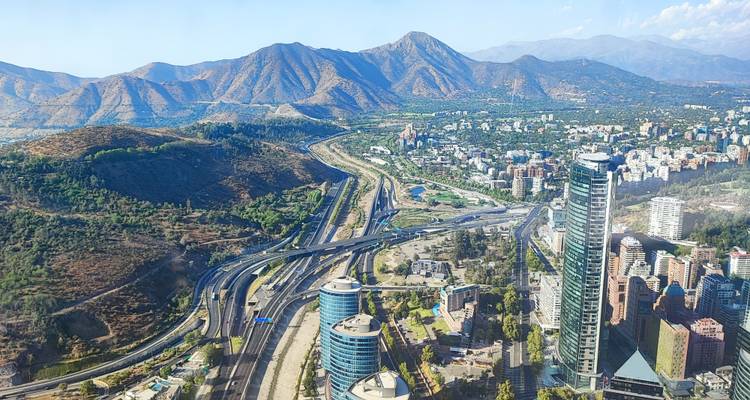 Moderne Skyline von Santiago mit hoch aufragenden Wolkenkratzern und Autobahnen, die sich in Richtung der Anden-Berge erstrecken.