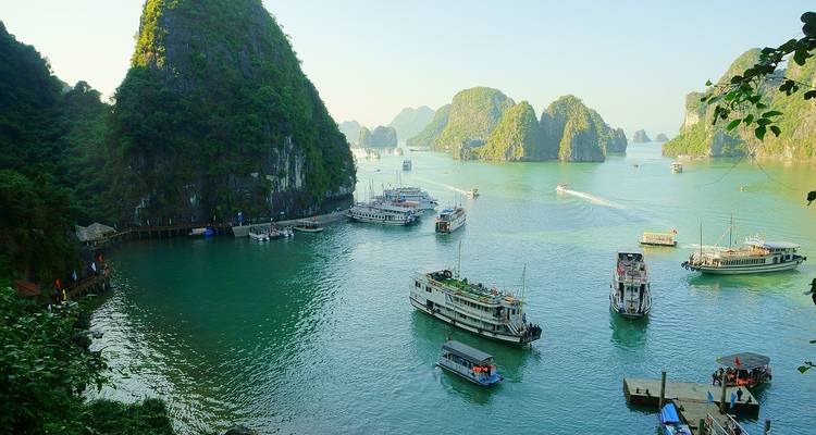 Schilderachtig uitzicht op Halong Bay met boten tussen kalkstenen karst-formaties.