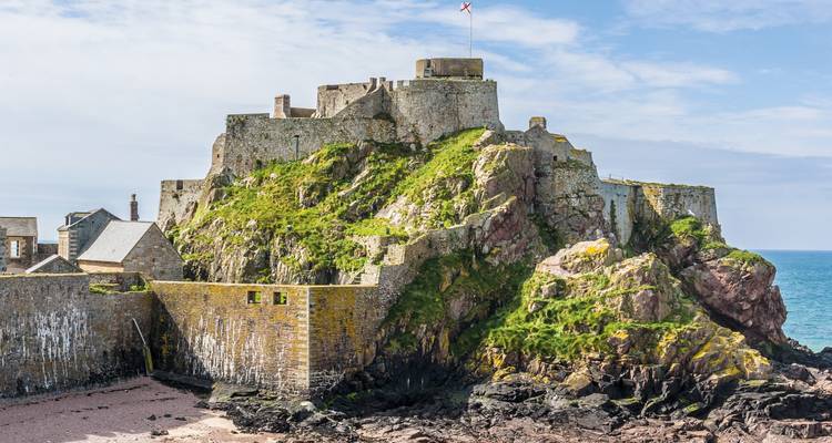 Château médiéval sur une falaise rocheuse au bord de la mer.