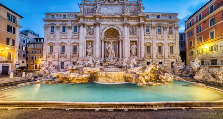 Die Abendlichter beleuchten das türkisfarbene Becken des Trevi-Brunnens vor seiner kunstvollen barocken Fassade.