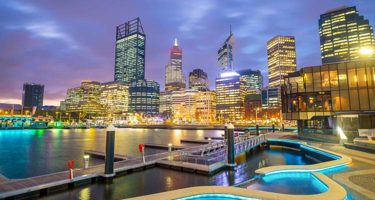 Vista nocturna de un horizonte urbano con rascacielos iluminados.