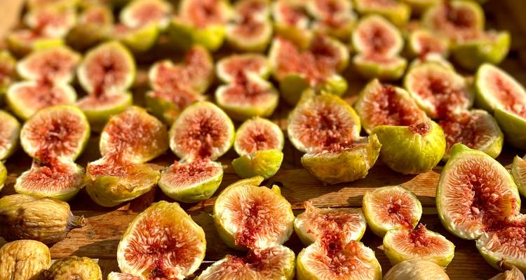 Nahaufnahme von frisch geschnittenen reifen Feigen, die auf einer Holzoberfläche ausgelegt sind