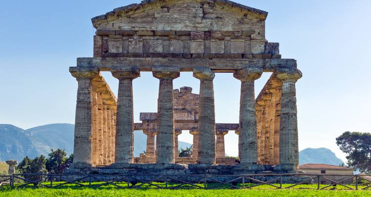 Antiker griechischer Steintempel mit stabilen Säulen vor fernen Bergen