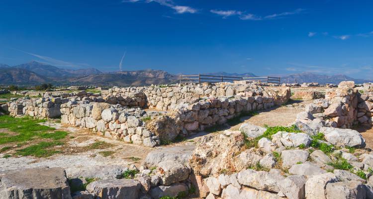 Steinruinen und Grundmauern einer antiken Zitadelle vor fernen Bergketten