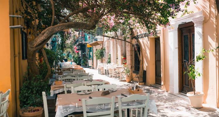Charmantes Gassen-Restaurant mit Tischen unter einem blühenden Bougainvillea-Dach im sanften Licht