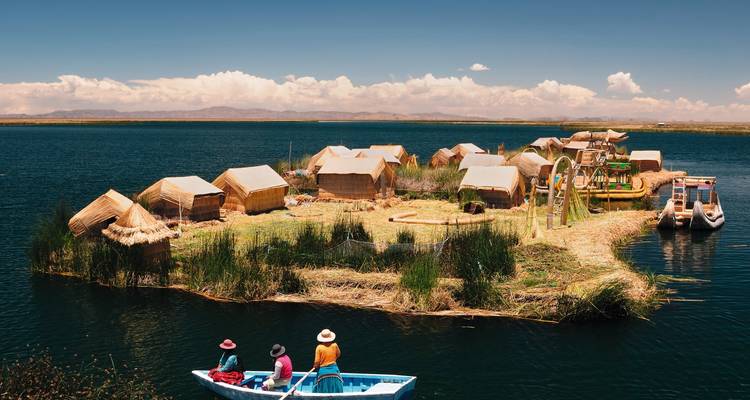 Schwimmendes Schilfdorf auf dem Titicacasee mit Booten und lebhaftem Himmel.