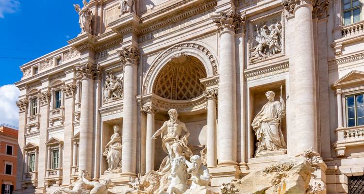 Sculptures de marbre et détails ornés de la façade de la fontaine de Trevi à Rome baignés dans un soleil éclatant.