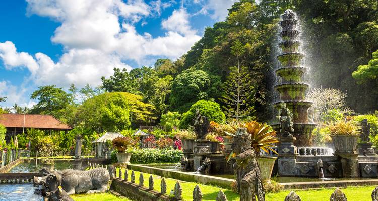 Springbrunnen, Statuen und üppige Gärten des Tirta Gangga Wasserpalastes glitzern unter Balis tropischer Sonne.