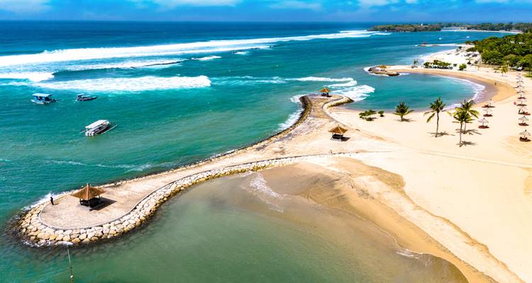 Luftaufnahme einer geschwungenen Sandnehrung und türkisfarbenen Gewässern von Nusa Duas geschütztem Strand.