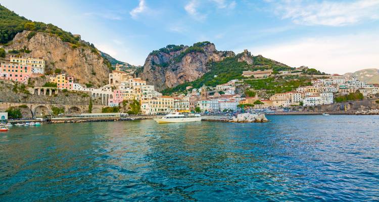 Charmante pastellfarbene Gebäude von Amalfi klammern sich an steile Klippen über dem türkisfarbenen Tyrrhenischen Meer.