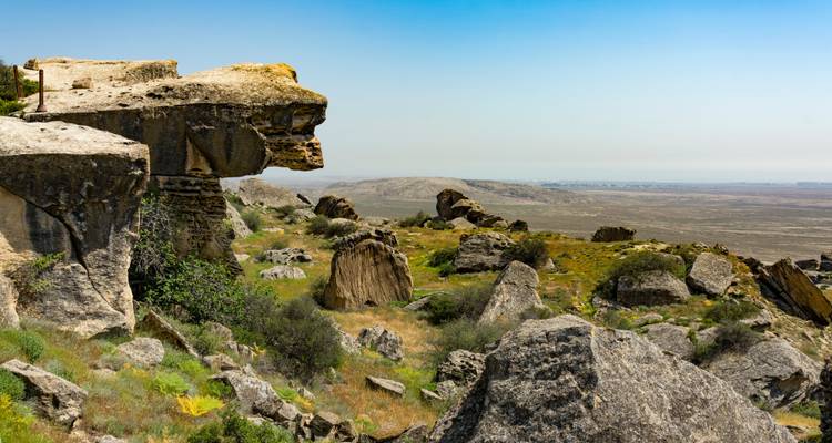 Rocky outcrop and boulders overlooking wide plains in Gobustan National Park.