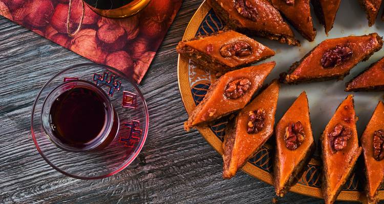 Traditional Azerbaijani pastries with tea on a wooden table.