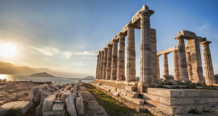 Der Poseidontempel thront auf einem felsigen Vorgebirge über der schimmernden Ägäis bei Sonnenuntergang