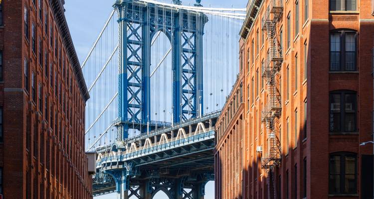 Le pont emblématique de Manhattan encadré entre des entrepôts en briques rouges dans le quartier de DUMBO.