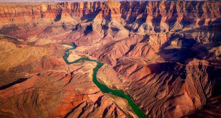 Vue aérienne époustouflante du Grand Canyon avec la rivière Colorado émeraude serpentant à travers des strates colorées.