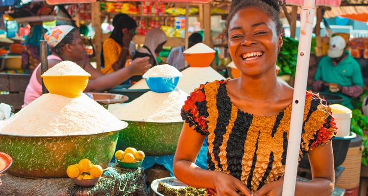 Joyful woman at an outdoor market stall.