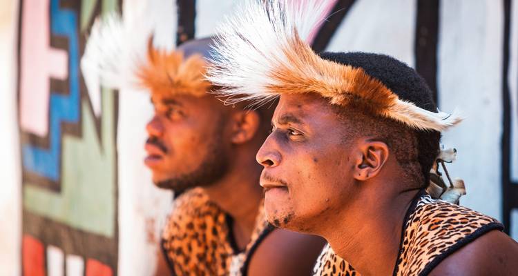 Two men in traditional attire sitting outdoors.