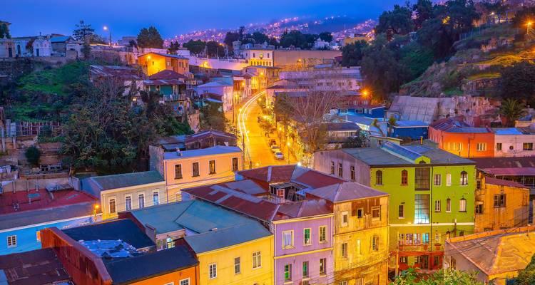 Colorful hillside houses of Valparaiso illuminated at twilight with a winding lit street through the scene