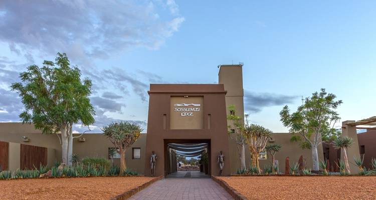 Entrance to a lodge with desert landscaping.