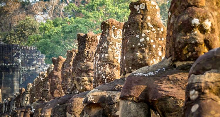 Des statues anciennes alignées avec des détails complexes dans un cadre de temple.