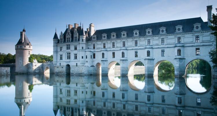 Stunning reflection of a château over water, likely Château de Chenonceau.