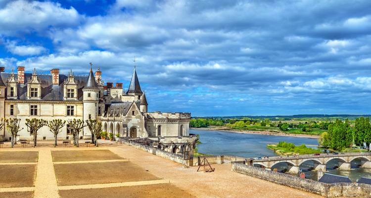 Vista panorámica del Castillo de Amboise encaramado sobre el río Loira y el puente de piedra.