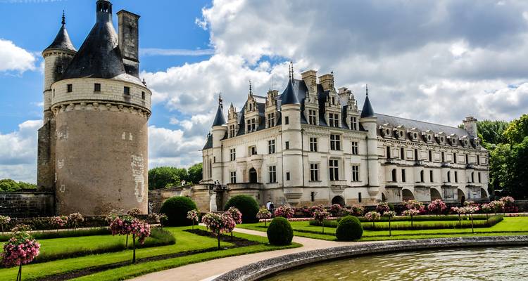 Beautiful château with gardens and a circular pond, possibly Château de Chenonceau.