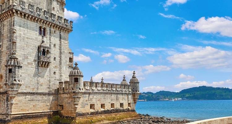 Belém-Turm nahe der Uferpromenade unter blauem Himmel.