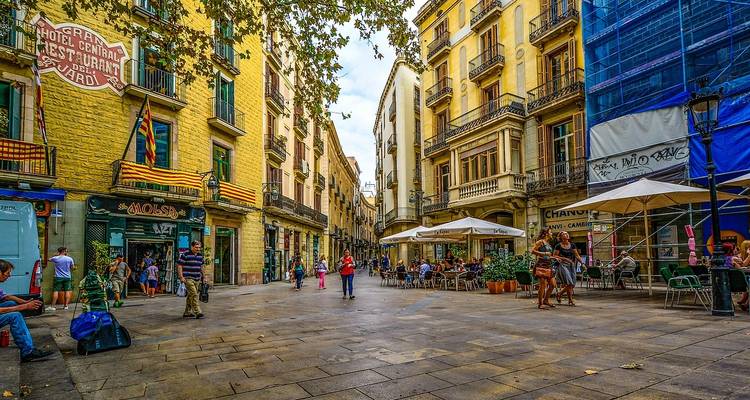 Een drukke straat in Barcelona met winkels en mensen.