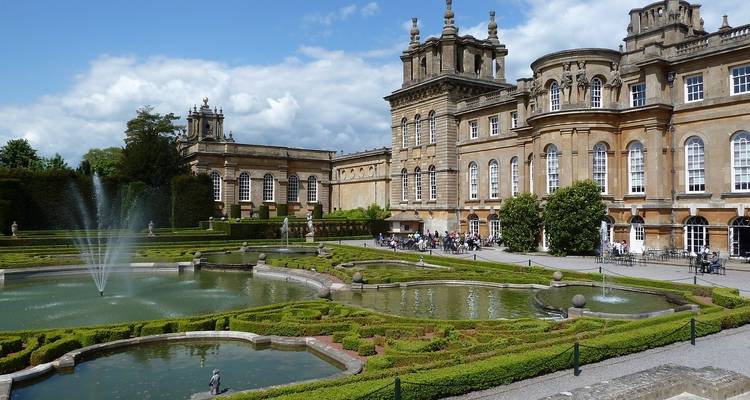 Historic building with formal gardens and fountains.
