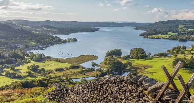 Scenic view of a lake surrounded by hills and greenery.