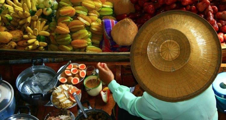 Person auf einem Boot mit verschiedenen Früchten und Lebensmitteln ausgestellt.