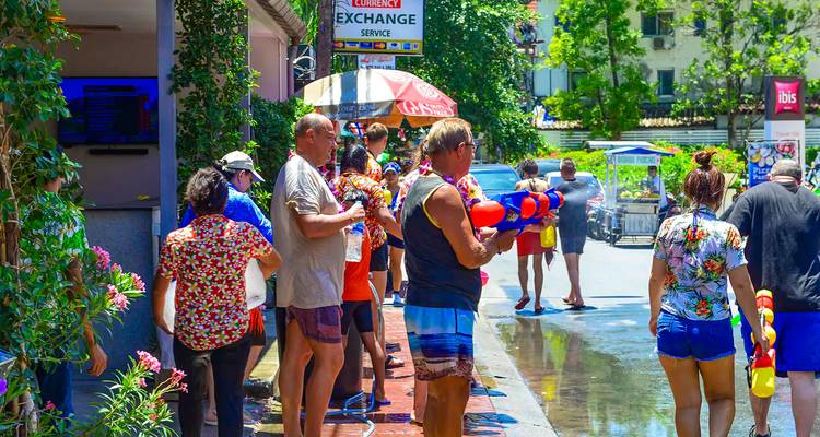 Des gens participant à un festival de l'eau dans une rue.