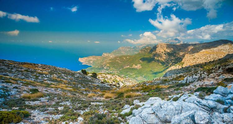 Chaîne de montagnes pittoresque avec l'océan au loin.