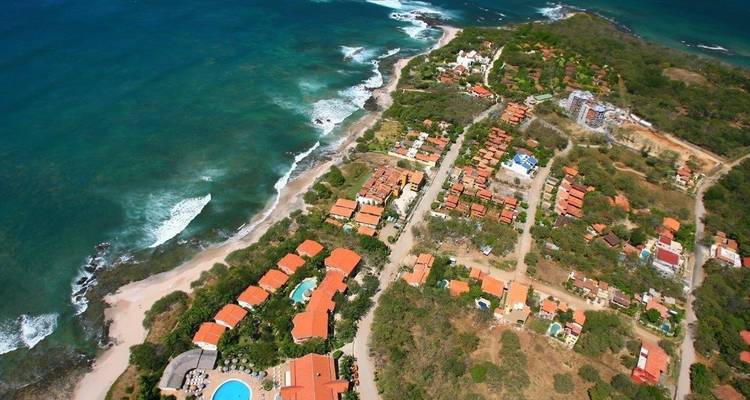 Vista aérea de un pueblo costero con aguas cristalinas.