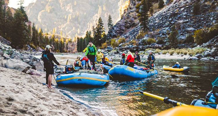 Rafting activity on a river with mountains in the background.