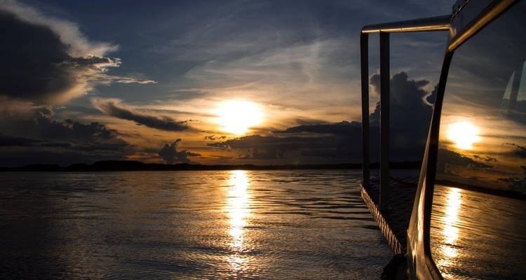Coucher de soleil sur une étendue d'eau avec un reflet.
