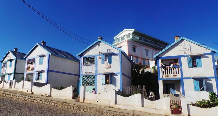 Kleurrijke huizen aan een zonnige straat in een landelijk gebied.