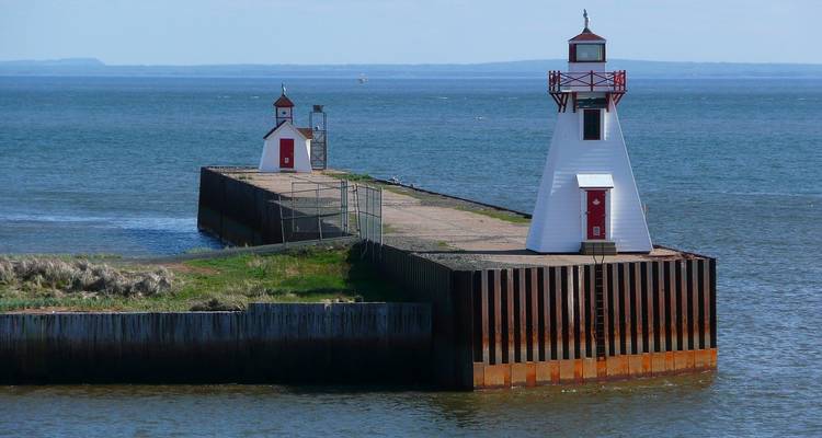 A unique pier with two small lighthouses amidst a tranquil ocean.