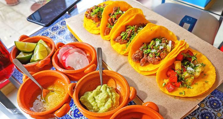 Kleurrijke taco's met verschillende vullingen op een dienblad.