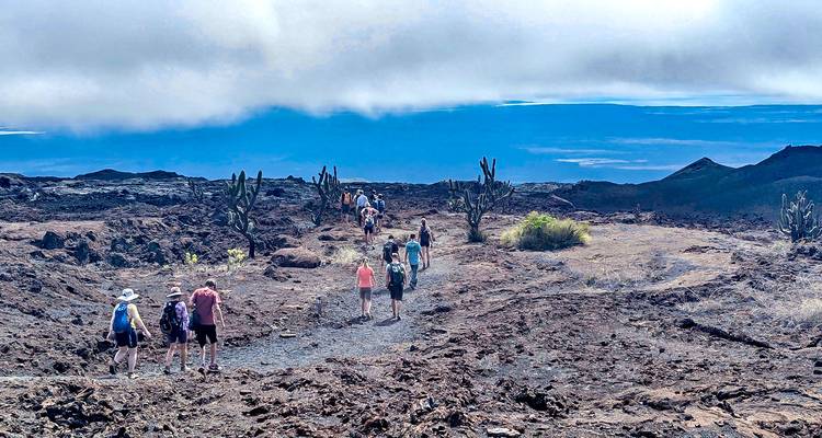 Wandelaars die door een vulkanisch landschap lopen.