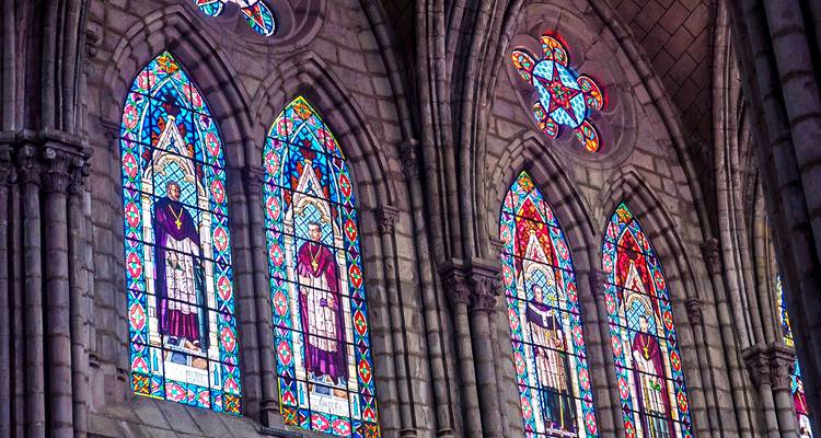 Eine Reihe bunter Buntglasfenster im Inneren einer Kirche.