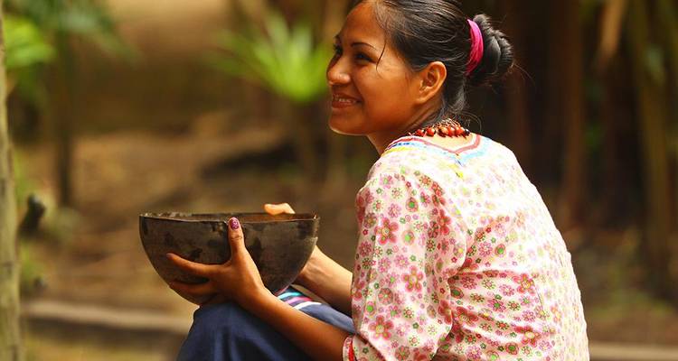 Persona sosteniendo un tazón tradicional y sonriendo.