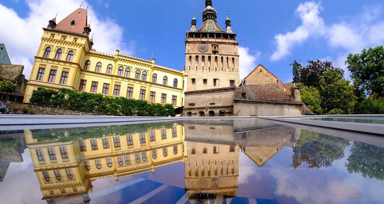 Historischer Turm mit einer Spiegelung auf Glas.