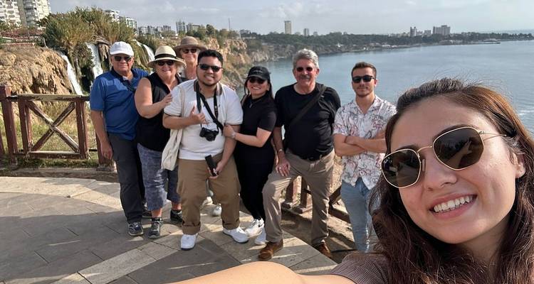 Groupe de touristes prenant un selfie avec un arrière-plan côtier.