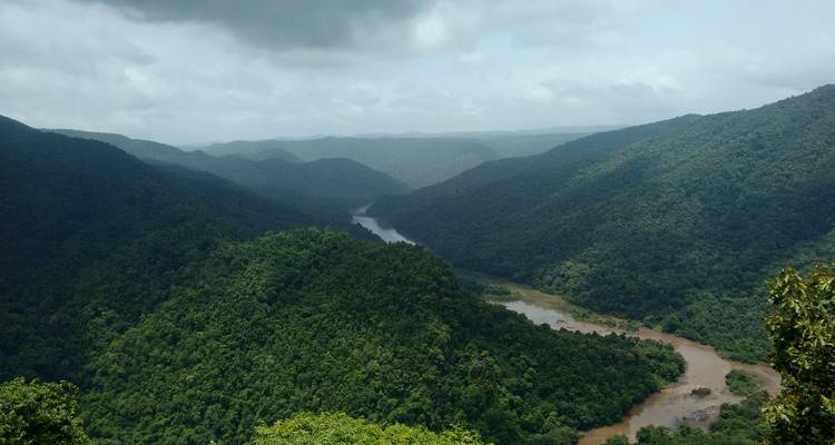 Vaste vallée verdoyante et luxuriante avec une rivière qui la traverse.