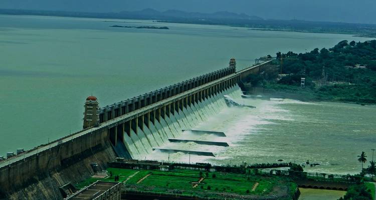 Großer Damm mit Wasser, das über den Überlauf herabstürzt.