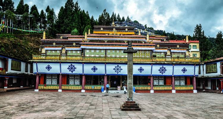 Large Buddhist monastery against a hillside backdrop.