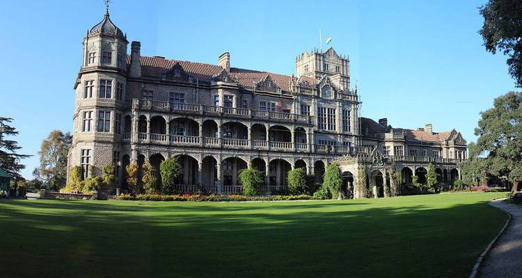 Historical building with multiple windows and greenery.